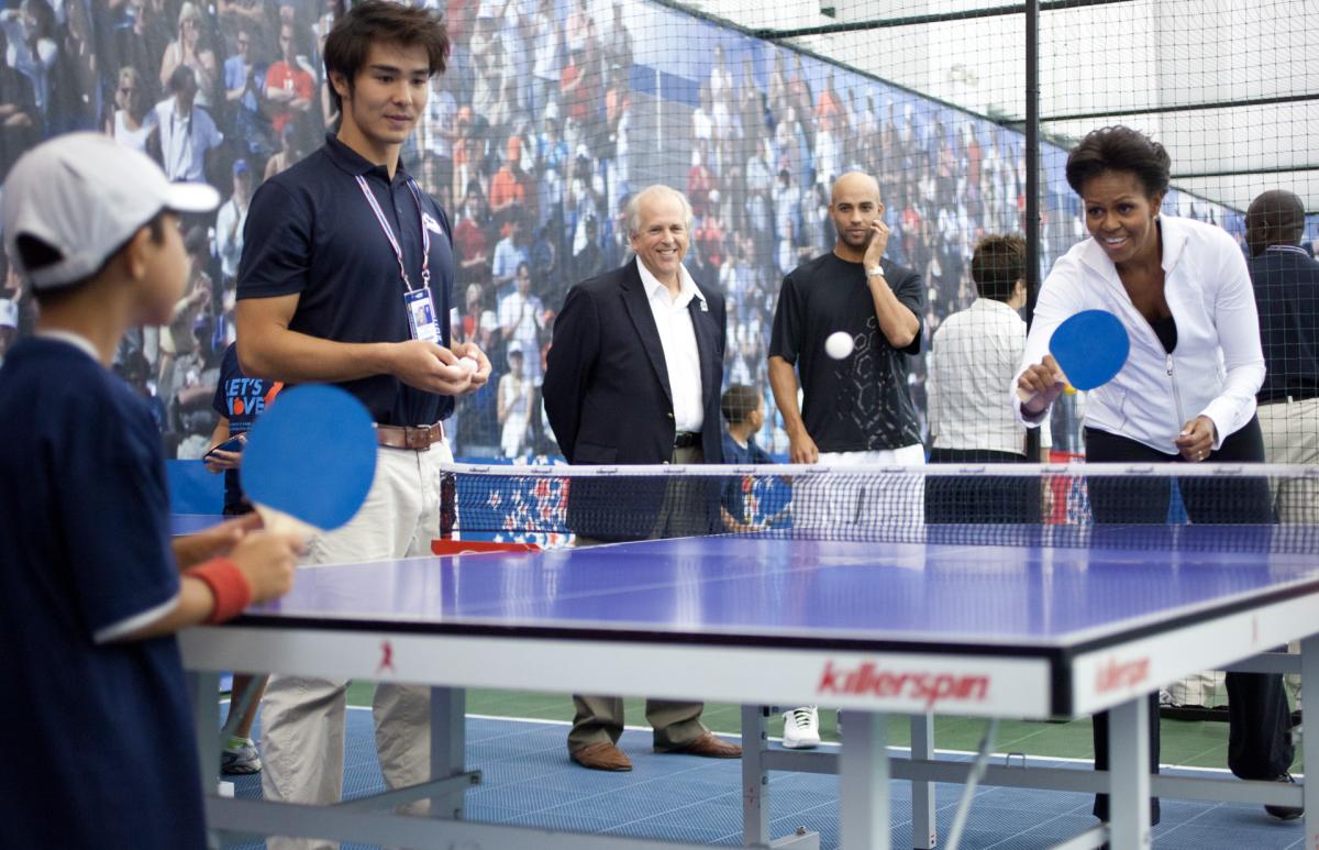 First Lady Michelle Obama plays table tennis with a young participant in a Let's Move! event 