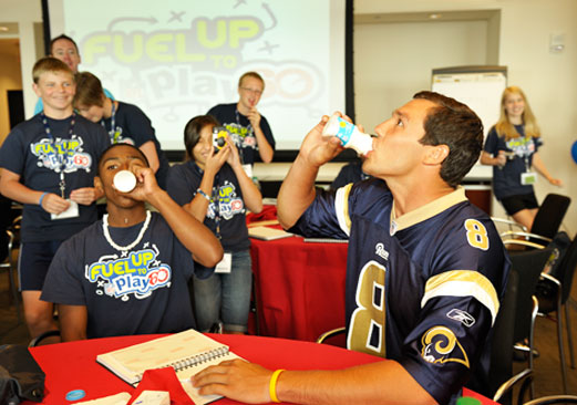 Sam Bradford joins kids drinking milk. 