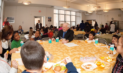 Agriculture Under Secretary for Food, Nutrition and Consumer Services Kevin W. Concannon (right) tries a few words of Spanish with Marlon DeBose (green shirt), and other students in this 2nd grade Spanish class seated at this table, in the Elsie Whitlow Stokes Community Freedom Public Charter School, on Wednesday, February 2, 2011.  The school is the first Washington, D.C. school to achieve the Gold Award of Distinction from the HealthierUS School Challenge (HUSSC).  They will now hold the certification and distinction for four years. The goal of the HUSSC is to improve the health of the Nation’s children by promoting healthier school environments. (U.S. Department of Agriculture photo by Lance Cheung)